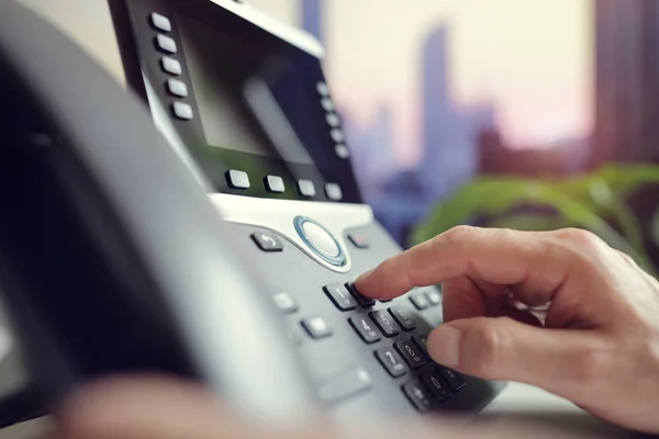 Zoomed image of man using VoIP telephone